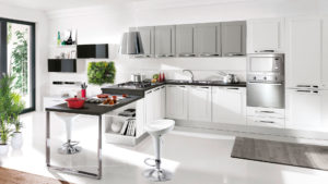 cucina moderna colore grigio e bianco che si sviluppa su una parete con colonne frigo e forno e penisola con piano cottura e piano snack