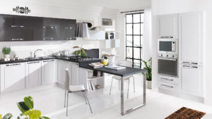 cucina moderna colore bianco che si sviluppa su una parete con colonne frigo e forno su altra parete e penisola con piano cottura e piano snack